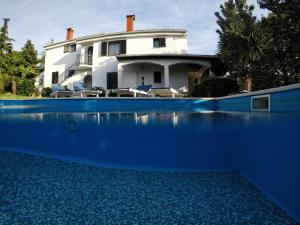 una casa con una piscina azul frente a ella en Studio Apartment Adriana en Poreč