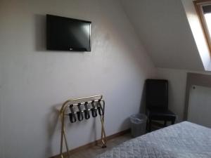 a bedroom with a bed and a tv on the wall at B&B 't Hemelbedje in Nieuwpoort