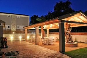 una pérgola con mesas y sillas en un patio en Astrakeroula Corfu, en Astrakeri