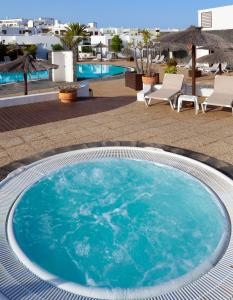 a large pool with blue water in a resort at Apartamentos LIVVO Coloradamar in Playa Blanca