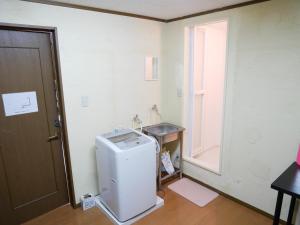 a small refrigerator in a room with a window at Guest House Twenty-Seven 27 in Osaka