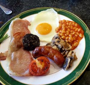 a plate of breakfast food with an egg and beans at Chadwell Hill Farm in Longwick +24 photos