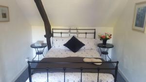 a bedroom with a black bed with two tables at La Metairie & Cottages in Camors