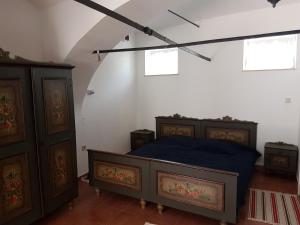 a bedroom with a bed and two wooden cabinets at Artemis Farmapartment in Loimeth