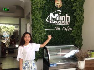 a woman standing in front of a restaurant sign at Minh Apartment in Danang