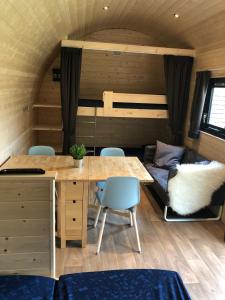 a tiny house with a table and chairs and a couch at Camping Ginsterveld in Burgh Haamstede +68 photos