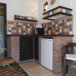 kuchnia z ceglaną ścianą i białą lodówką w obiekcie Casa Lareymora w mieście Algarrobo