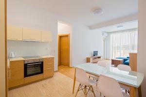 a kitchen and dining room with a table and chairs at Eukaliptus in Bečići