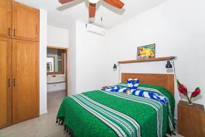 a bedroom with a green bed and a ceiling fan at Villa Colima in Sayulita