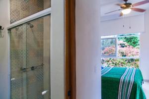 a bathroom with a shower and a window and a ceiling fan at Villa Colima in Sayulita