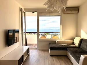 a living room with a couch and a large window at Seaview Apartment in Koper