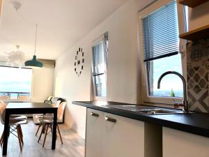 a kitchen with a sink and a table with chairs at Seaview Apartment in Koper