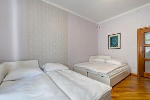 ソポトにあるDR Apartments - Seagullの白い壁とウッドフロアの客室で、ベッド2台が備わります。
