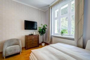 ソポトにあるDR Apartments - Seagullのベッドルーム(ベッド1台、テレビ、椅子付)