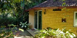 a small yellow building with a sliding glass door at Baandin Chiewlarn in Ban Ta Khun