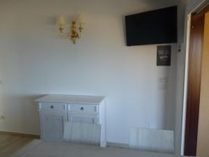 a room with a white cabinet and a television on a wall at Residenze Paradiso in Costa Paradiso