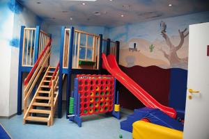 una sala de juegos para niños con un tobogán y un parque infantil en Marco Polo Alpina Familien- & Sporthotel, en Maria Alm am Steinernen Meer