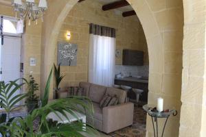 a living room with a couch in a stone wall at Simar in Qala