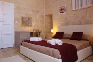 a bedroom with a bed with towels on it at Simar in Qala +15 photos
