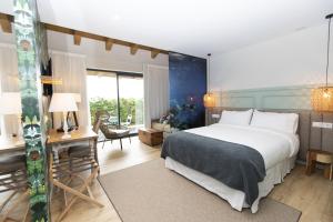 a bedroom with a large bed and a desk and a room at Hotel Mi Norte in Ribadeo