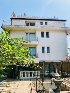 a large white building with a balcony on top of it at Guesthouse in Chernomorets next to Gradina and Sozopol in Chernomorets