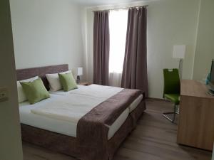 a bedroom with a bed and a desk and a window at Hotel Hof Münsterland in Ahlen