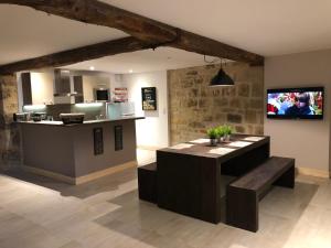 泰爾拉松的住宿－Les Maisons du Périgord，厨房配有带长凳和柜台的柜台。