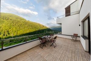 a balcony with a table and chairs on a building at Apartament Carol Sinaia in Sinaia