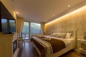 a bedroom with a large bed and a television at Apartament Carol Sinaia in Sinaia