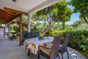einen Tisch und Stühle auf der Terrasse eines Hauses in der Unterkunft Giselle in Mali Lošinj