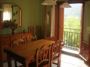 uma sala de jantar com uma mesa de madeira e uma varanda em Casa Paban em Murillo de Liena