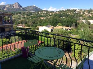 a balcony with a table and chairs and mountains at La Vençoise in Vence