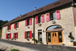 a large brick building with red shutters on it at Domaine et chambres d'Hôtes des Fées in Pretin