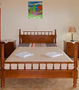 ein Holzbett mit zwei Handtüchern darüber in der Unterkunft Ellinas Homes in Megáli Mandínia