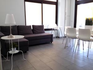 un soggiorno con un divano, un tavolo e delle sedie di Chitamar ad Arona