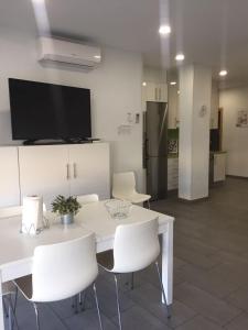 una sala da pranzo con un tavolo bianco e sedie bianche di Chitamar ad Arona