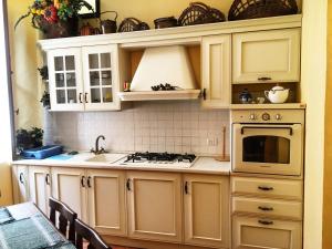 a kitchen with white cabinets and a sink and a stove at Scalea Historic Center Apartments in Scalea