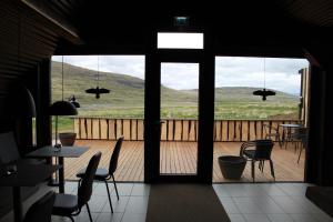 a room with a view of a deck with tables and chairs at Dalahyttur in Hlíð í Hörðudal