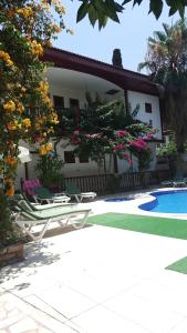 a house with a swimming pool and some chairs and flowers at Kaleiçi Ozkavak Hotel in Antalya