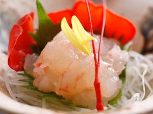 un plato de sushi con arroz y tomates. en Seaside Hotel Geibousou, en Shima