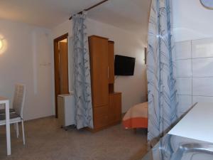 Cet appartement comprend une chambre avec un lit et une télévision. dans l'établissement Studio apartment Lucija, à Privlaka