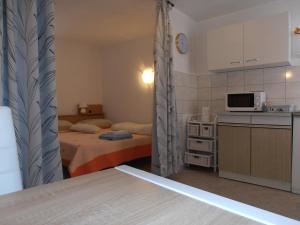une petite chambre avec un lit et une cuisine dans l'établissement Studio apartment Lucija, à Privlaka