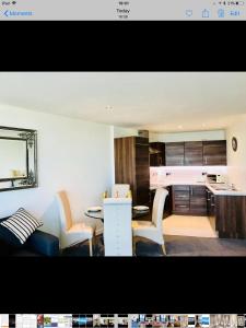 ベルファストにあるLuxury 2 Bedroom Apartment in Prime City Locationのキッチン、リビングルーム(テーブル、椅子付)