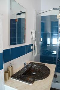 ein Bad mit einem Waschbecken und einer Dusche in der Unterkunft Hotel La Favorita in Cala Gonone