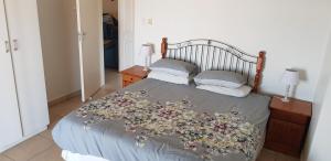 ein Schlafzimmer mit einem Bett mit Blumen darauf in der Unterkunft Sea La Vie Hibberdene in Hibberdene