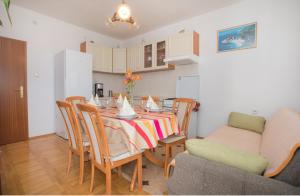 a kitchen and dining room with a table and chairs at Apartmani Branko Lemac in Brodarica +18 photos