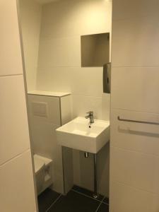 a white bathroom with a sink and a toilet at Hotel 55 - City Centre in Amsterdam