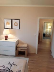 a living room with a white dresser and a chair at Apartment Graz Murpromenade in Graz