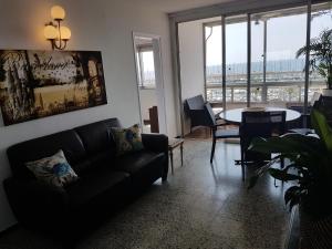 Lydia's Port Nautic & Beach في ماسنو: غرفة معيشة مع أريكة وطاولة
