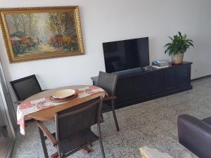 a living room with a table and a tv at Lydia's Port Nautic & Beach in Masnou